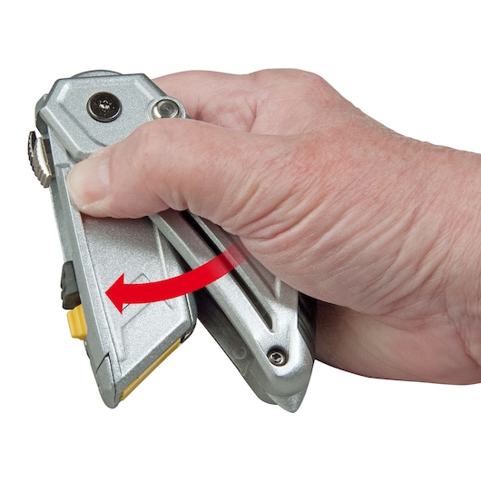 STANLEY XTHT0-10502 utility knife in hand, shown rotating with red arrow, close-up photo.