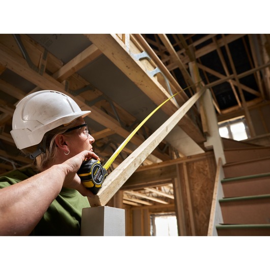 Photo of STANLEY XTHT0-33501 tape measure used on staircase in construction site.