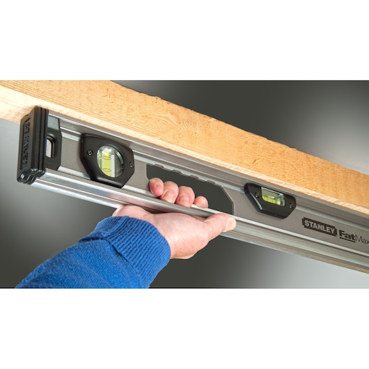 STANLEY XTHT1-42131 spirit level photography, close-up showing handle and bubble vials in use.